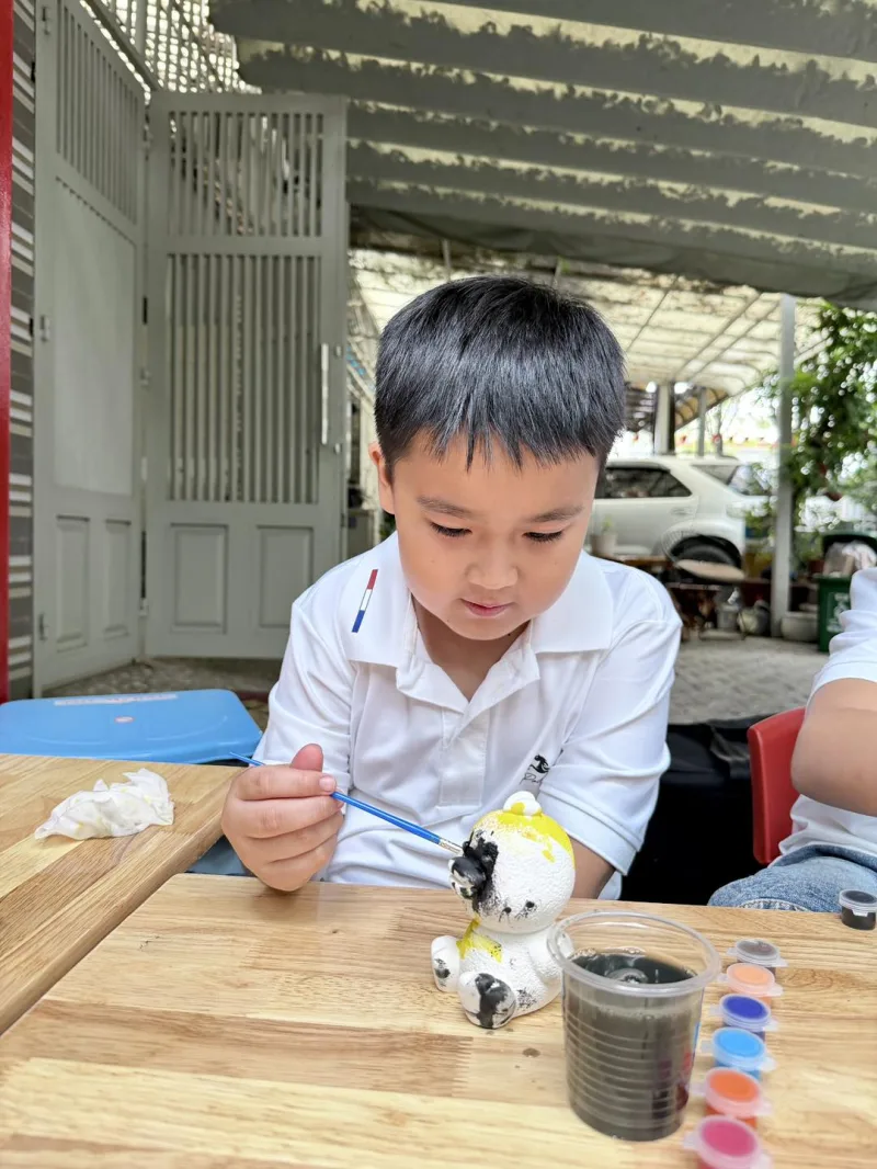 Bé trai tô tượng thạch cao đầy tập trung 🖌️