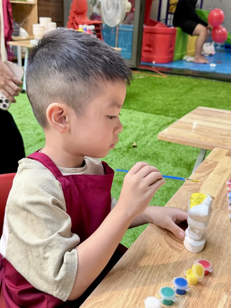 Bé mặc tạp dề, tô tượng nghiêm túc lắm nè 🎨